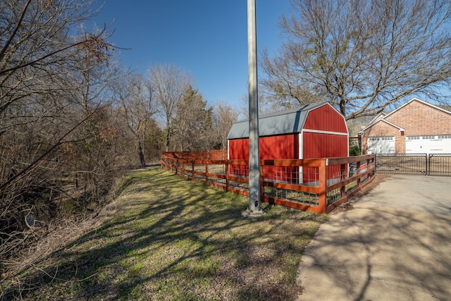 view of yard with an outbuilding, a barn, and fence