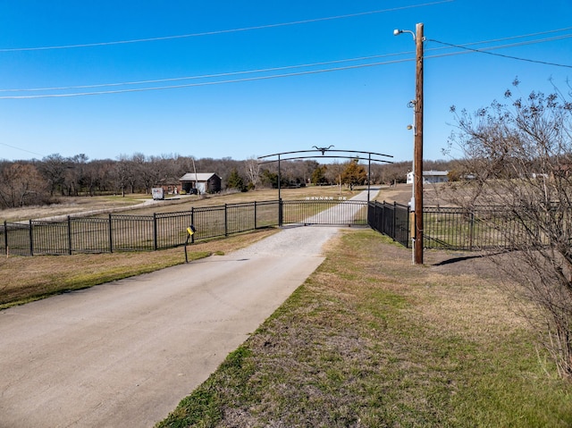 view of road with driveway, a gated entry, and a gate