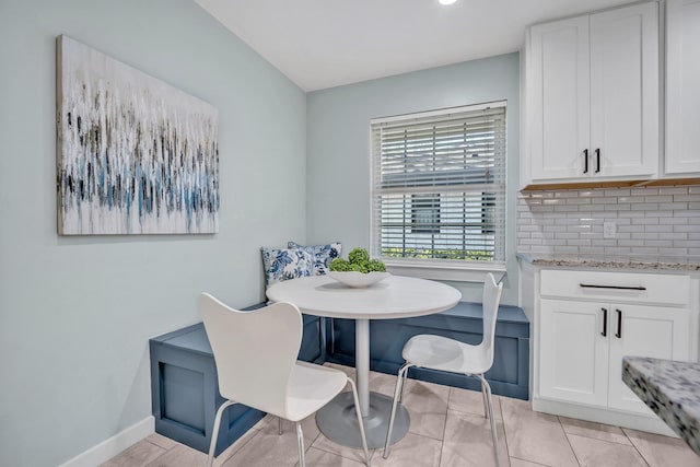 dining area with breakfast area, light tile patterned flooring, and baseboards