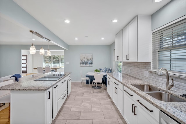 kitchen featuring decorative backsplash, a sink, a kitchen island, light stone countertops, and dishwasher