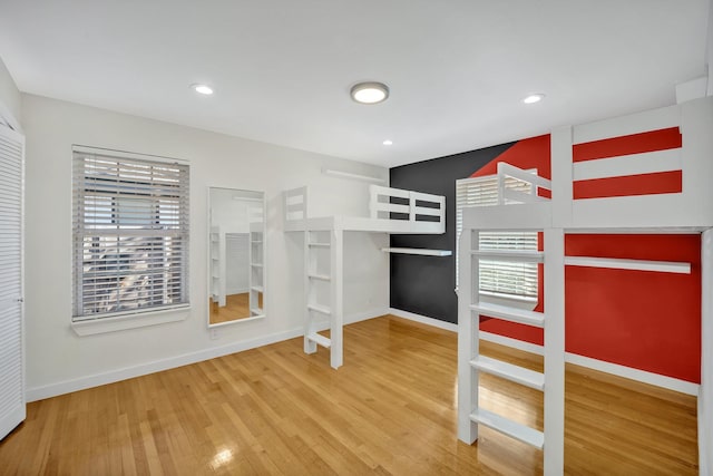 unfurnished bedroom with recessed lighting, baseboards, and wood finished floors