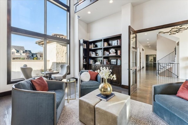 interior space featuring recessed lighting, stairway, a towering ceiling, wood finished floors, and baseboards