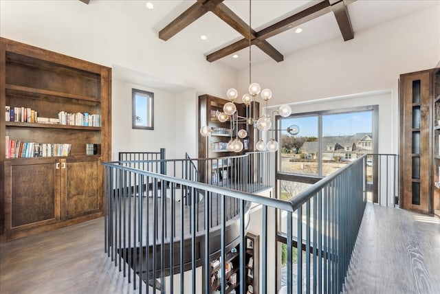 hall featuring coffered ceiling, wood finished floors, beam ceiling, and a notable chandelier