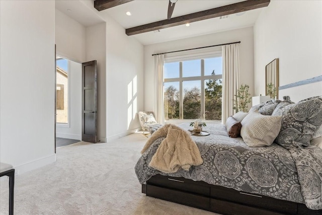 carpeted bedroom with beam ceiling and baseboards