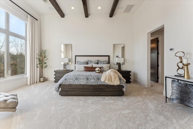 bedroom with beamed ceiling, multiple windows, carpet flooring, and visible vents