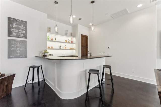 bar featuring wet bar, visible vents, hanging light fixtures, and baseboards