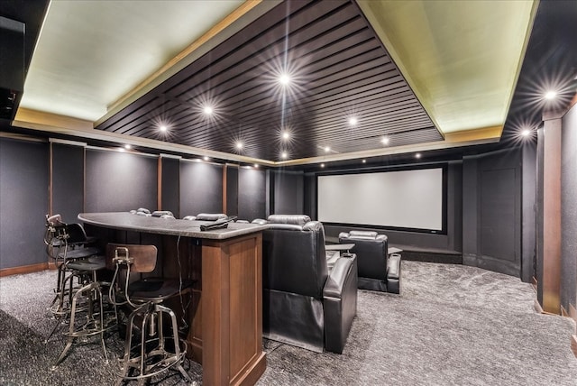 cinema room featuring carpet, a decorative wall, and a dry bar