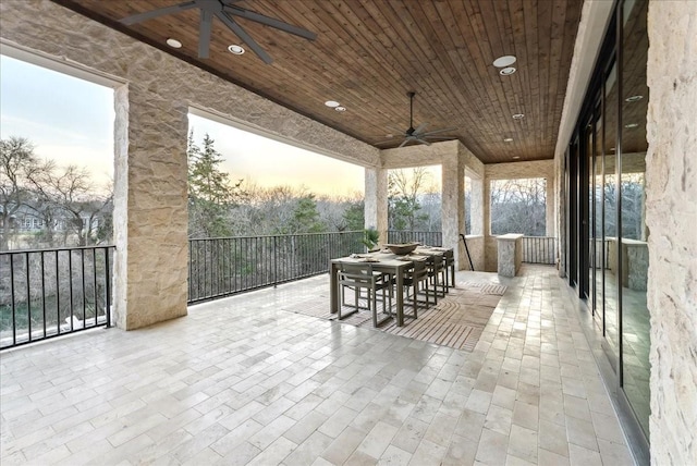 patio terrace at dusk with ceiling fan and outdoor dining area