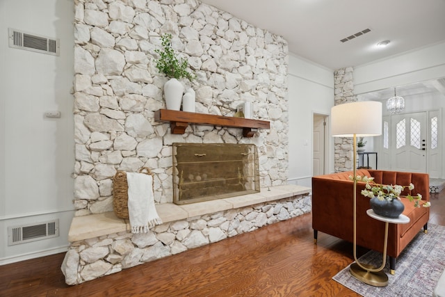 interior space with a fireplace, wood finished floors, and visible vents