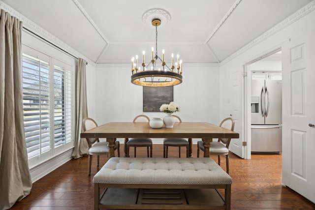 dining space featuring an inviting chandelier, ornamental molding, vaulted ceiling, and hardwood / wood-style floors