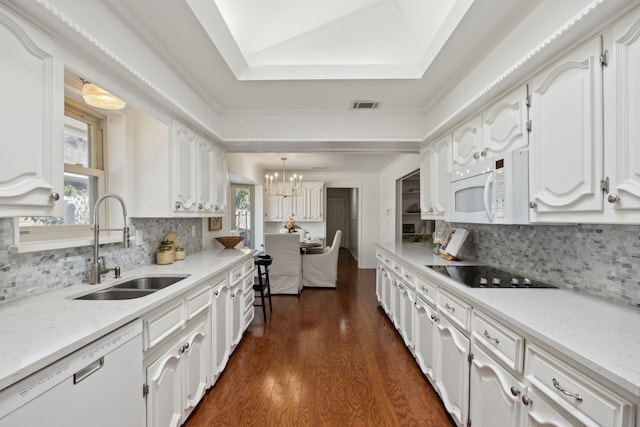 kitchen featuring white appliances, a sink, visible vents, white cabinets, and dark wood-style floors