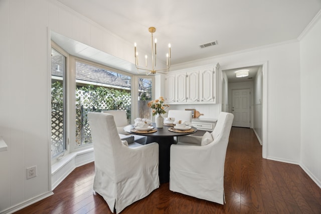 dining area with baseboards, visible vents, dark wood-type flooring, crown molding, and a chandelier