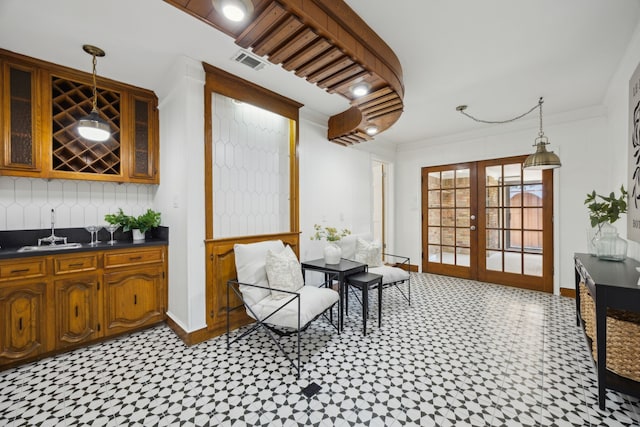 sitting room with french doors, visible vents, crown molding, and baseboards