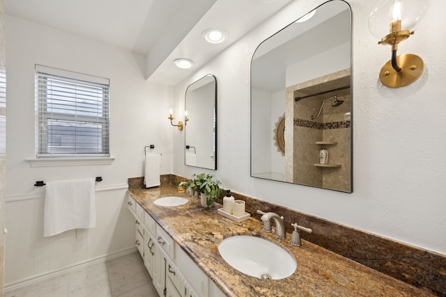 full bathroom with double vanity, a wainscoted wall, marble finish floor, and a sink