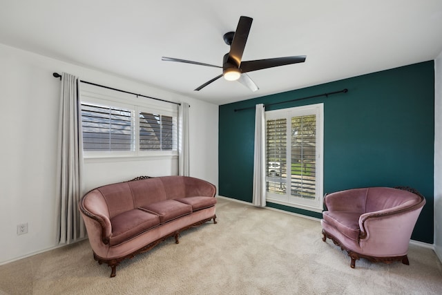 living area with ceiling fan and carpet