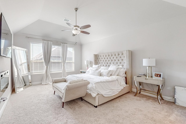 bedroom with a ceiling fan, lofted ceiling, light colored carpet, and visible vents