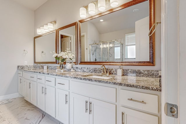 bathroom featuring marble finish floor, double vanity, a sink, and a shower stall