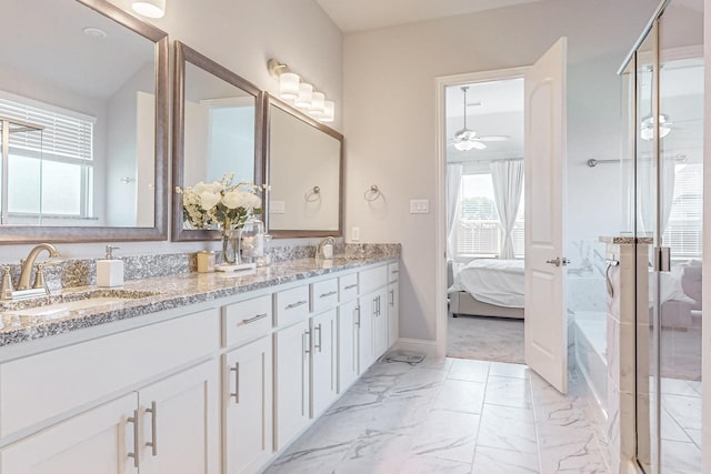 ensuite bathroom featuring marble finish floor, double vanity, ensuite bathroom, a ceiling fan, and a sink