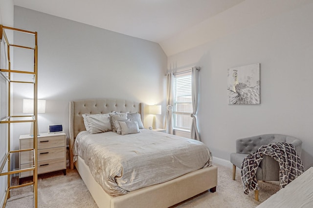 carpeted bedroom featuring lofted ceiling and baseboards