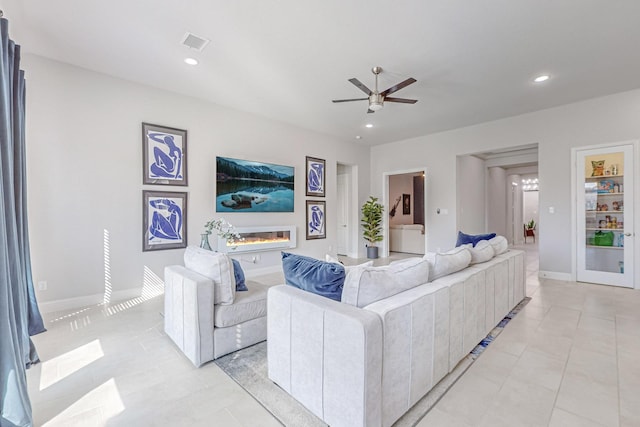 living room with recessed lighting, visible vents, a ceiling fan, and a glass covered fireplace