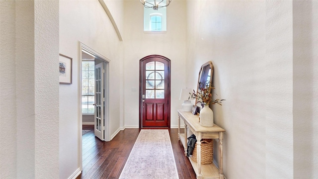 foyer with dark wood-style floors, a high ceiling, baseboards, and a wealth of natural light