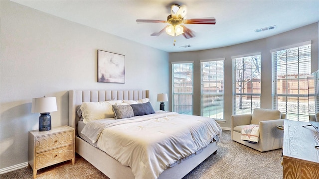 carpeted bedroom with visible vents, ceiling fan, and baseboards