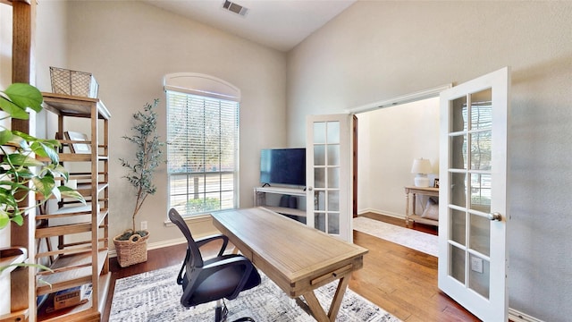 home office with french doors, wood finished floors, visible vents, and baseboards