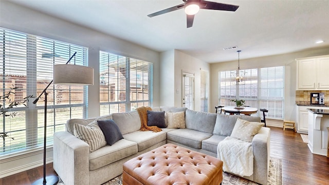 living area featuring dark wood-style floors, plenty of natural light, visible vents, and a ceiling fan