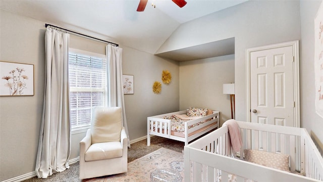 bedroom featuring lofted ceiling, carpet flooring, ceiling fan, a nursery area, and baseboards