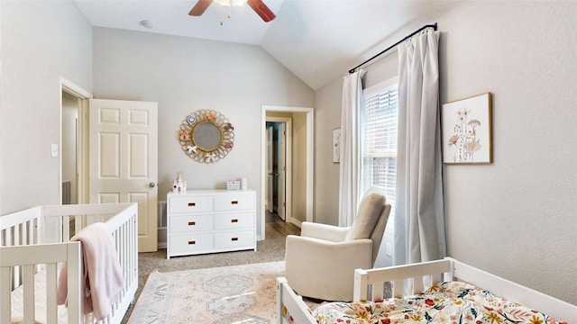 bedroom featuring light colored carpet, a ceiling fan, vaulted ceiling, a nursery area, and baseboards