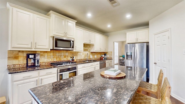 kitchen featuring a large island, recessed lighting, visible vents, backsplash, and appliances with stainless steel finishes