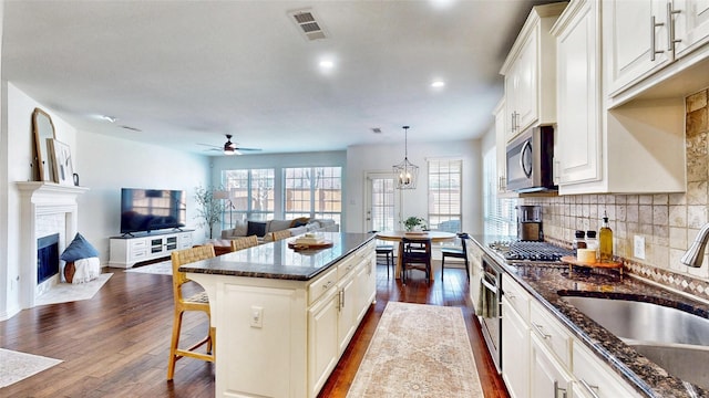 kitchen with dark wood finished floors, visible vents, stainless steel appliances, and a sink