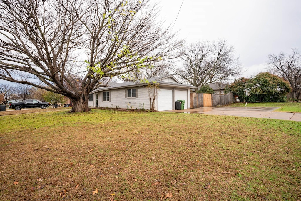 673 W Cedar St, Hurst, TX 76053 - view of front of home featuring a garage, driveway, a front yard, and fence