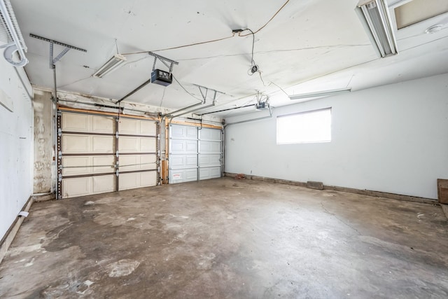 garage with baseboards and a garage door opener