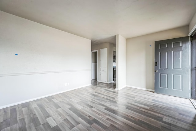 empty room featuring baseboards and wood finished floors