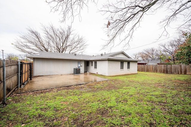 rear view of house featuring central air condition unit, a patio area, a fenced backyard, and a yard