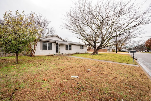 view of front of house with brick siding and a front yard