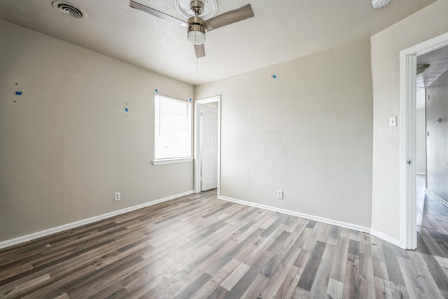 unfurnished room with baseboards, ceiling fan, visible vents, and wood finished floors