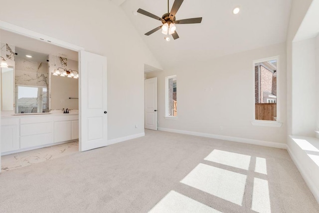 unfurnished bedroom with light carpet, baseboards, ensuite bathroom, high vaulted ceiling, and recessed lighting