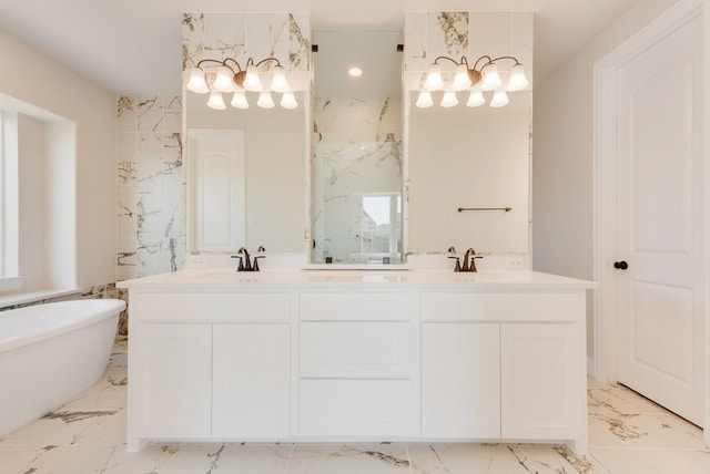 bathroom with marble finish floor, double vanity, a freestanding tub, and a sink