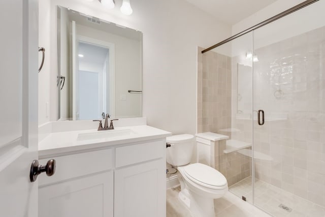 bathroom featuring toilet, a stall shower, and vanity