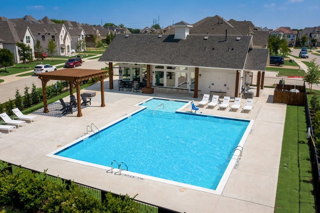 community pool with a residential view, a patio, and fence