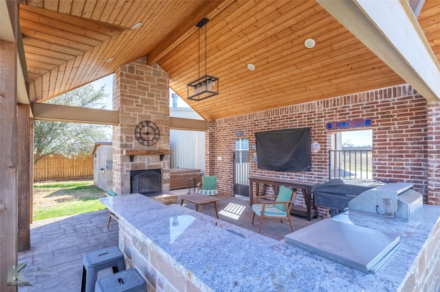 357 County Road 337, Tuscola, TX 79562 - view of patio featuring area for grilling, an outdoor kitchen, fence, and an outdoor stone fireplace