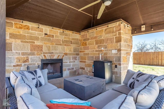 357 County Road 337, Tuscola, TX 79562 - view of patio / terrace with ceiling fan, an outdoor living space with a fireplace, and fence