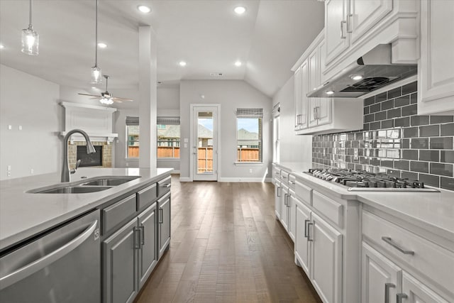 kitchen with stainless steel appliances, tasteful backsplash, gray cabinets, light countertops, and a sink