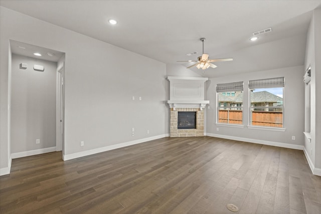 unfurnished living room featuring a ceiling fan, visible vents, dark wood-type flooring, and a stone fireplace