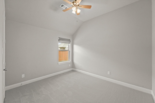 unfurnished room with baseboards, visible vents, a ceiling fan, light colored carpet, and vaulted ceiling