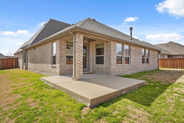 rear view of property featuring a fenced backyard, ceiling fan, a yard, a patio area, and brick siding