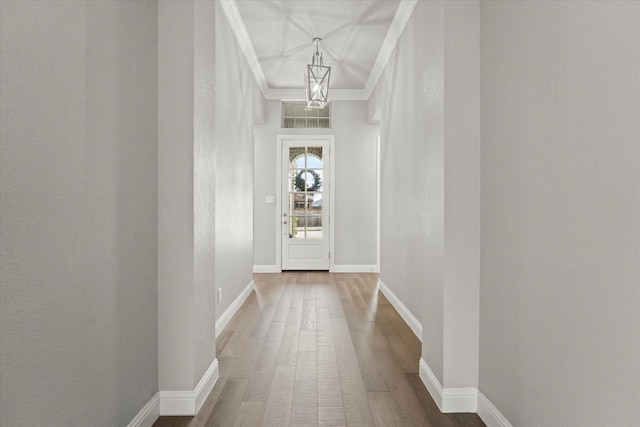 entryway with visible vents, crown molding, baseboards, and wood finished floors