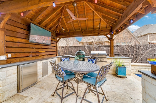 view of patio / terrace featuring a gazebo, area for grilling, outdoor dining space, and fence